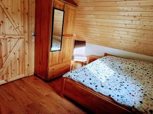 - une chambre avec un lit et un mur en bois dans l'établissement Yellow House, à Wąglikowice