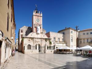 un grande edificio in pietra con torre dell'orologio di Apartments Klanac a Zara (Zadar)