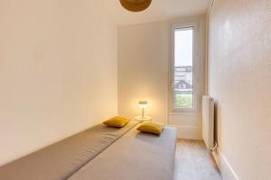 Cette chambre comprend un lit avec deux oreillers jaunes. dans l'établissement Appartement entier au coeur de Nogent Sur Marne, à Nogent-sur-Marne