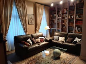 a living room with two leather couches and a table at L'Appartement in Valence-dʼAgen