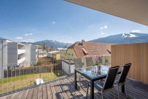 balcón con mesa de cristal, sillas y montañas en Apartment Gitti Obermoser, en Radstadt