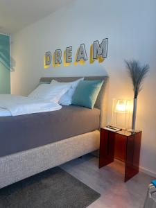 un dormitorio con una cama con la palabra sueño en la pared en SIR WALTER Work & Stay, HOMEOFFICE, W-LAN en Neuss
