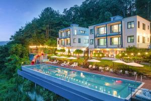um hotel com piscina em frente a um edifício em Die Pause Pool villa Pension em Gapyeong