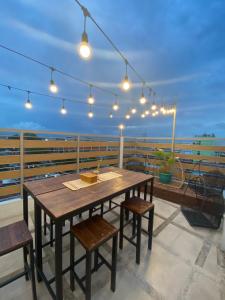 a wooden table and chairs on a roof with lights at Rain Airport Bed and Breakfast in Manila