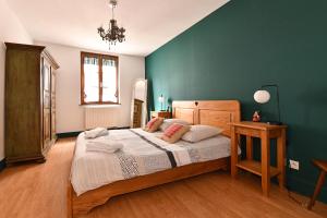 een slaapkamer met een groot bed en een groene muur bij Au Nid d'Hirondelles in Ribeauvillé