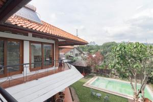 a house with a balcony and a swimming pool at RedDoorz Plus near Dago Pakar in Bandung
