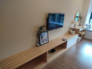 a living room with a bench with a flat screen tv at Ceylonz Suites, casa for your holiday in Kuala Lumpur