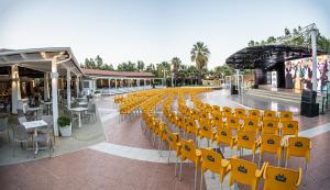 rząd żółtych krzeseł na chodniku w obiekcie 4 Mori Family Village - Villaggio per Famiglie w mieście Muravera