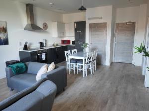 uma sala de estar e cozinha com um sofá e uma mesa em Modern Two Bedroom Apartment - Central Peterborough em Peterborough