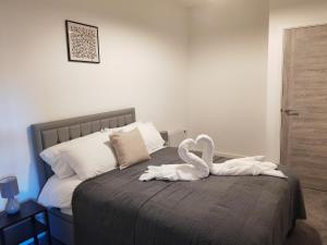 uma decoração de cisne numa cama num quarto em Modern Two Bedroom Apartment - Central Peterborough em Peterborough