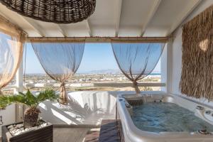 a bath tub in a room with a large window at Black Velvet in Agkidia