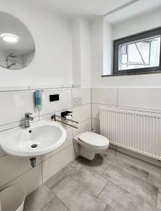 a white bathroom with a sink and a toilet at The Manhattan A Boutique Hotel By American Ease in Grafenwöhr