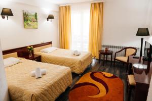a hotel room with two beds and a table at Casa Octavian in Suceviţa +88 photos