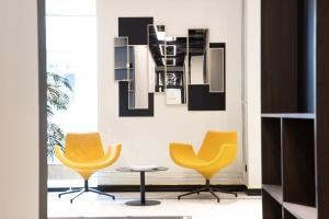 two yellow chairs and a table in a room at Tempus Te Premium Duo Lofts Tartu - private cinema, gym and terrace in Tartu