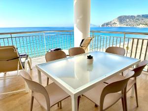 a white table and chairs on a balcony with the ocean at Porto Azul 10A Frontal Peñon & Sea View First Line Arenal Beach in Calpe