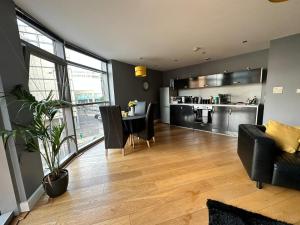 sala de estar con mesa y sillas y cocina en Fantastic and modern city centre flat with FREE parking!, en Cardiff