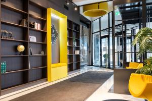 a yellow door in a library with bookshelves at Tempus Te Premium Duo Lofts Tartu - private cinema, gym and terrace in Tartu