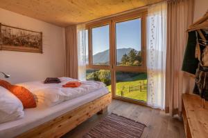 um quarto com uma cama e uma grande janela em Feldhasen em Bad Ischl