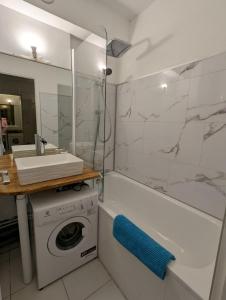 a bathroom with a washing machine and a sink at Studio hyper centre in Luchon