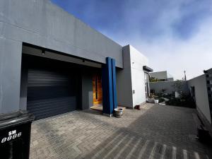 ein Gebäude mit einer Garage mit blauem Mast in der Unterkunft 5078 Swakopmund in Swakopmund