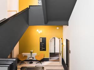 a staircase with yellow walls and orange chairs at Tempus Te Premium Duo Lofts Tartu - private cinema, gym and terrace in Tartu