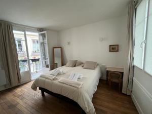 a bedroom with a large bed with towels on it at Aux Terrasses de la Lune in Paris