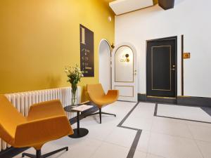 a waiting room with orange chairs and a door at Tempus Te Premium Duo Lofts Tartu - private cinema, gym and terrace in Tartu