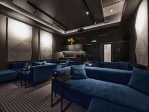a waiting room with blue couches and a screen at Tempus Te Premium Duo Lofts Tartu - private cinema, gym and terrace in Tartu