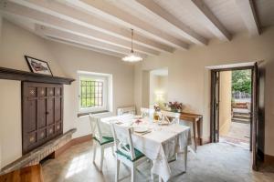 een eetkamer met een witte tafel en stoelen bij Casa Gelsomina in Gardone Riviera