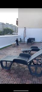 um cão sentado ao lado de um banco num pátio em Terrazze Alelà apartment em Bari