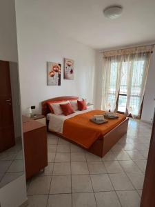 um quarto com uma cama grande e um cobertor laranja em Casa Cialde- Juventus stadium-Reggia di Venaria em Turim