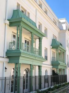 Un grand bâtiment blanc avec balcon est disponible. dans l'établissement Cosy Apartment Near Disneyland Paris, à Serris