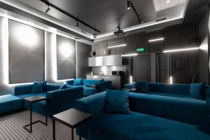 a living room with blue couches and a kitchen at Tempus Te Premium Duo Lofts Tartu - private cinema, gym and terrace in Tartu