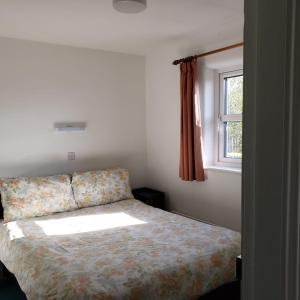1 dormitorio con cama y ventana en Louisburgh Cottages, en Louisburgh