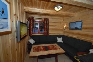 ein Wohnzimmer mit einem Sofa und einem Tisch in der Unterkunft Skibyen Jons Hytte in Skoro