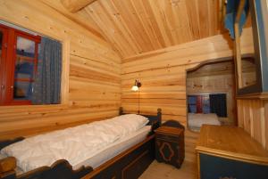 a bedroom in a log cabin with a bed in it at Skibyen Jons Hytte in Skoro