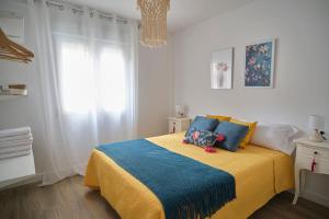 1 dormitorio con 1 cama con manta azul y amarilla en Vivienda Oasis Feria, en Albacete