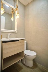 a bathroom with a toilet and a sink and a mirror at Vivienda Oasis Feria in Albacete