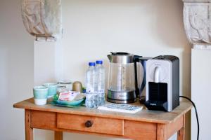 a table with a coffee maker and a blender on it at Côté cour, côté source chambre d'hôtes in Chaudfontaine