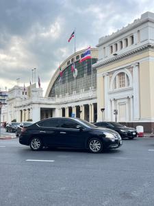 a black limousine parked in front of a building at Mr Black & Ms White -Self Check in accommodation in Pom Prap