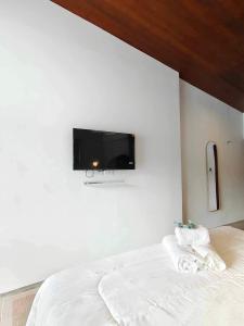 a bedroom with a bed with a tv on the wall at Mr Black & Ms White -Self Check in accommodation in Pom Prap