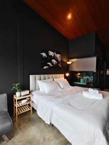 a bedroom with a large white bed and a fireplace at Mr Black & Ms White -Self Check in accommodation in Pom Prap
