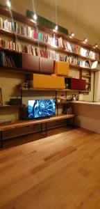 a living room with a tv on a shelf with books at Residenza tre spighe in San Felice del Benaco