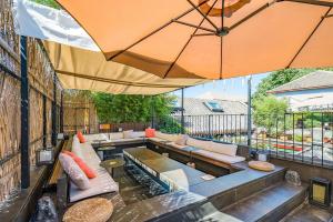 a patio with couches and an umbrella at 北京悦明元星空白塔景观四合院民宿 in Beijing