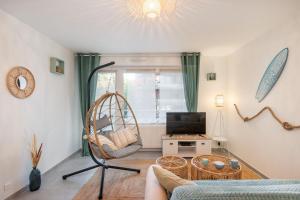a living room with a swing chair and a television at Beach Resort - Casa Vostra - CAUTION 800 EUR & ID requises - Saint Julien Centre-Gare in Saint-Julien-en-Genevois