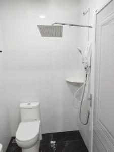 a white bathroom with a toilet and a shower at Afeeya The Roomstay in Kuala Terengganu