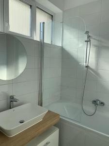 baño blanco con ducha y lavamanos en BB Residence en Arad