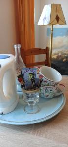 慕尼黑的住宿－Privatzimmer 15 qm，桌子上带两个杯子和茶壶的盘子