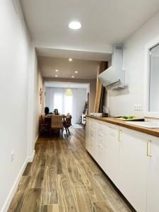 a kitchen with white cabinets and a dining room at Vivienda Oasis Feria in Albacete