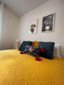 a bedroom with a large yellow bed with two pillows at Vivienda Oasis Feria in Albacete +5 photos